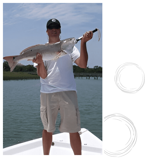 A man holding a fish on top of a boat.